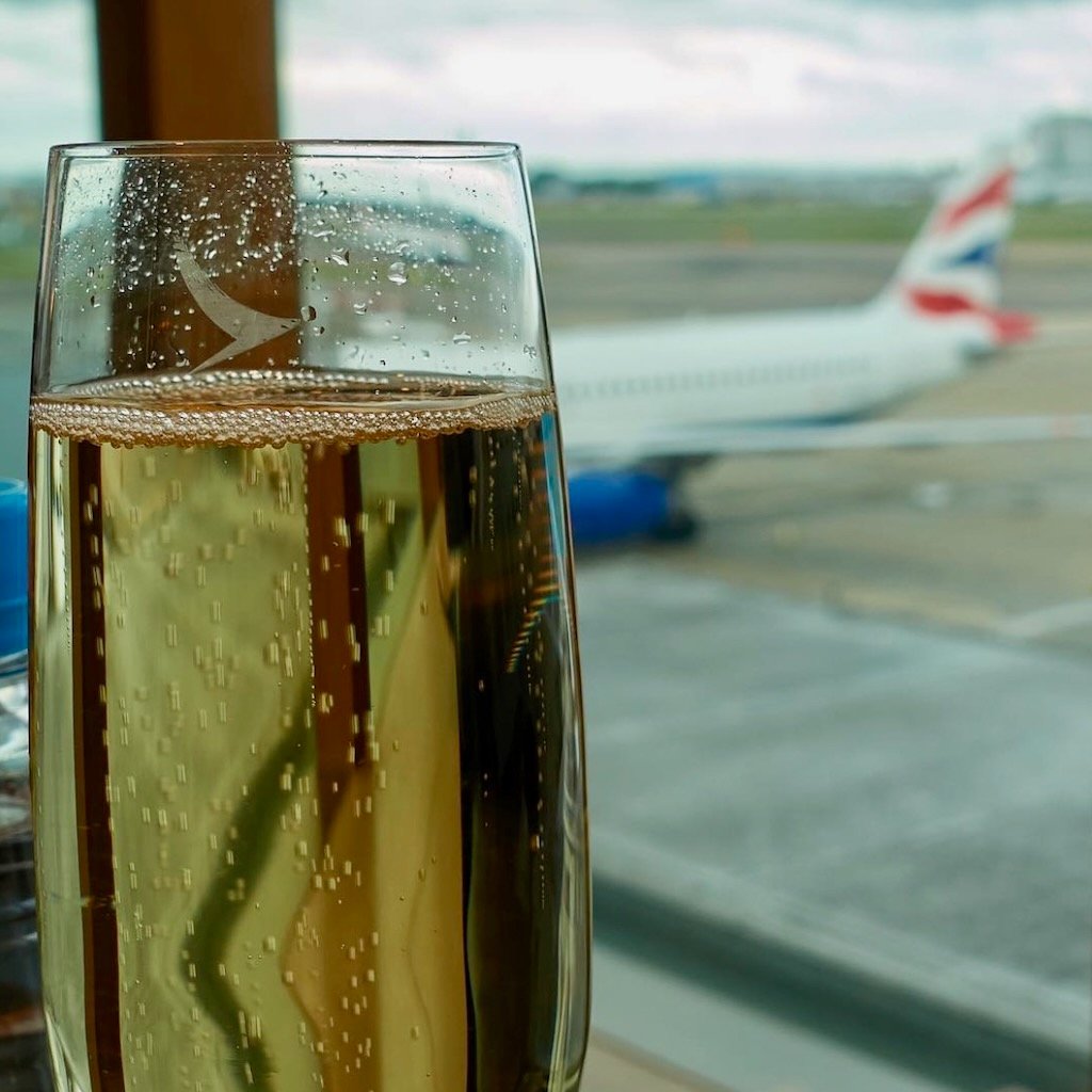 Welcome to Business Class Nuts.  Champagne in the Cathay Pacific First Class lounge at London Heathrow, with a British Airways plane in the background.